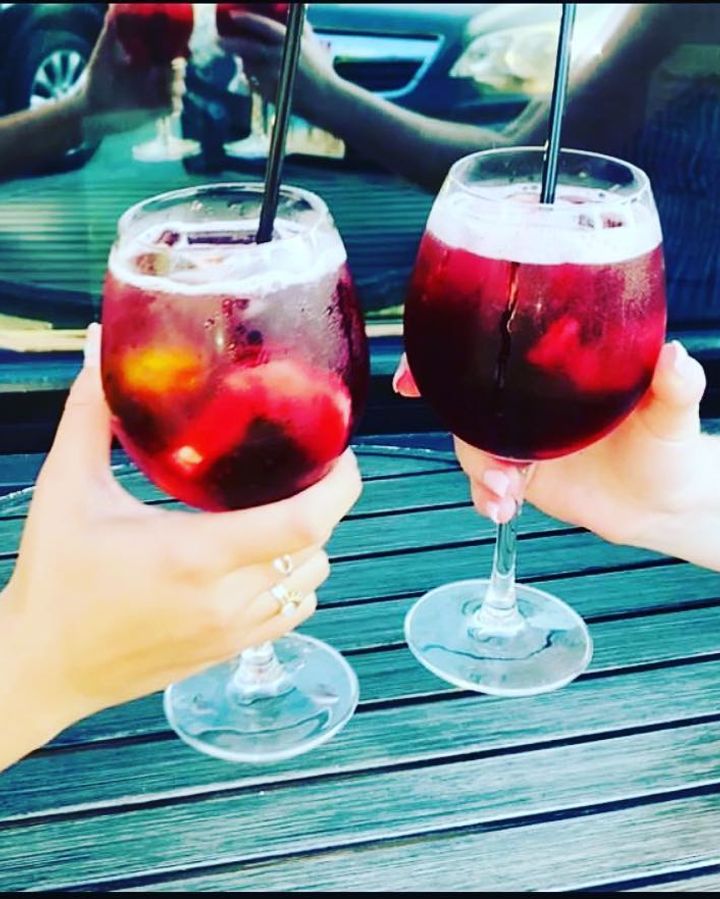 Friends raising sangria glasses by the window