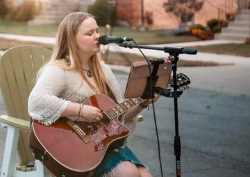 Acoustic singer performing outdoors on the Porter Cullens patio