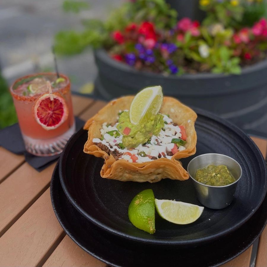 Blood orange margarita beside a tostada