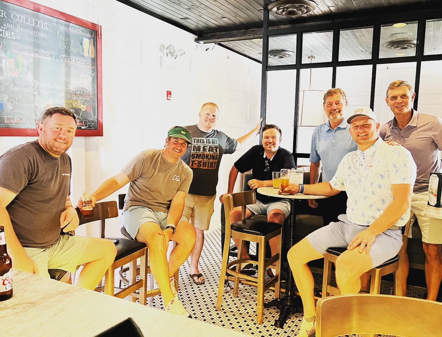Friends gathered on bar stools in the private event room