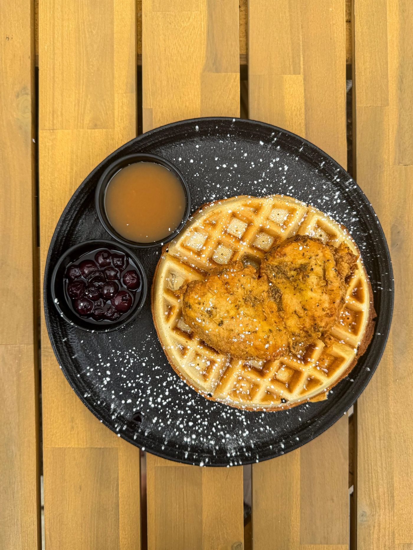 Chicken and waffles with syrup and blueberries
