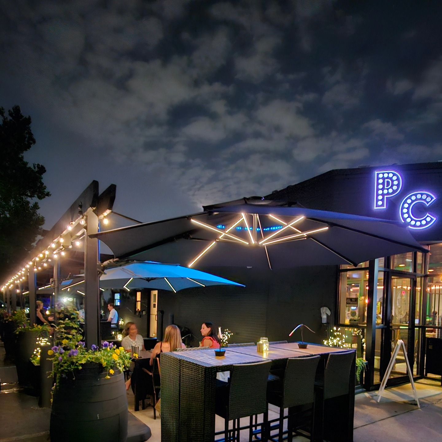 Porter Cullens patio lit up at night with the PC sign
