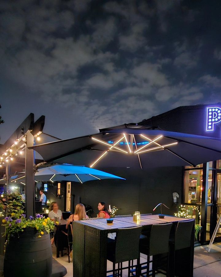 Porter Cullens patio lit up at night with the PC sign