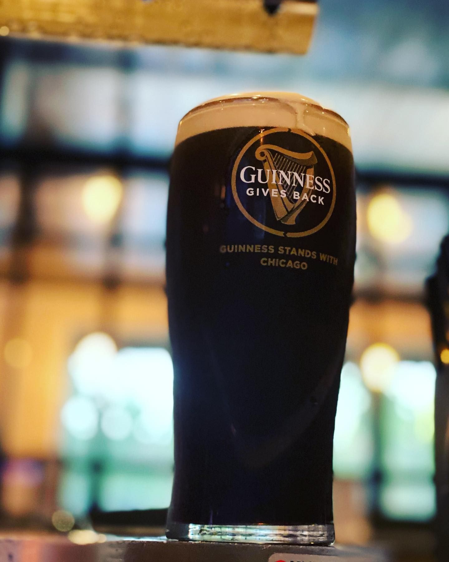Guinness pint with Chicago city lights in the background