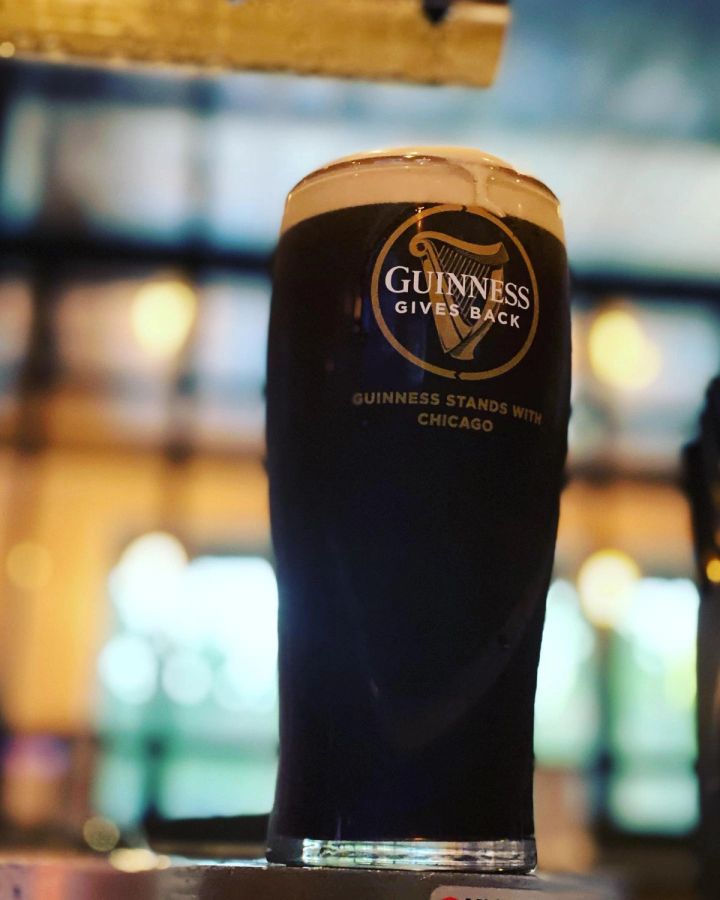 Guinness pint with Chicago city lights in the background