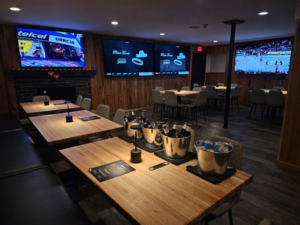 The private party room at Porter Cullens — wood-panelled walls, fireplace, TVs and table seating