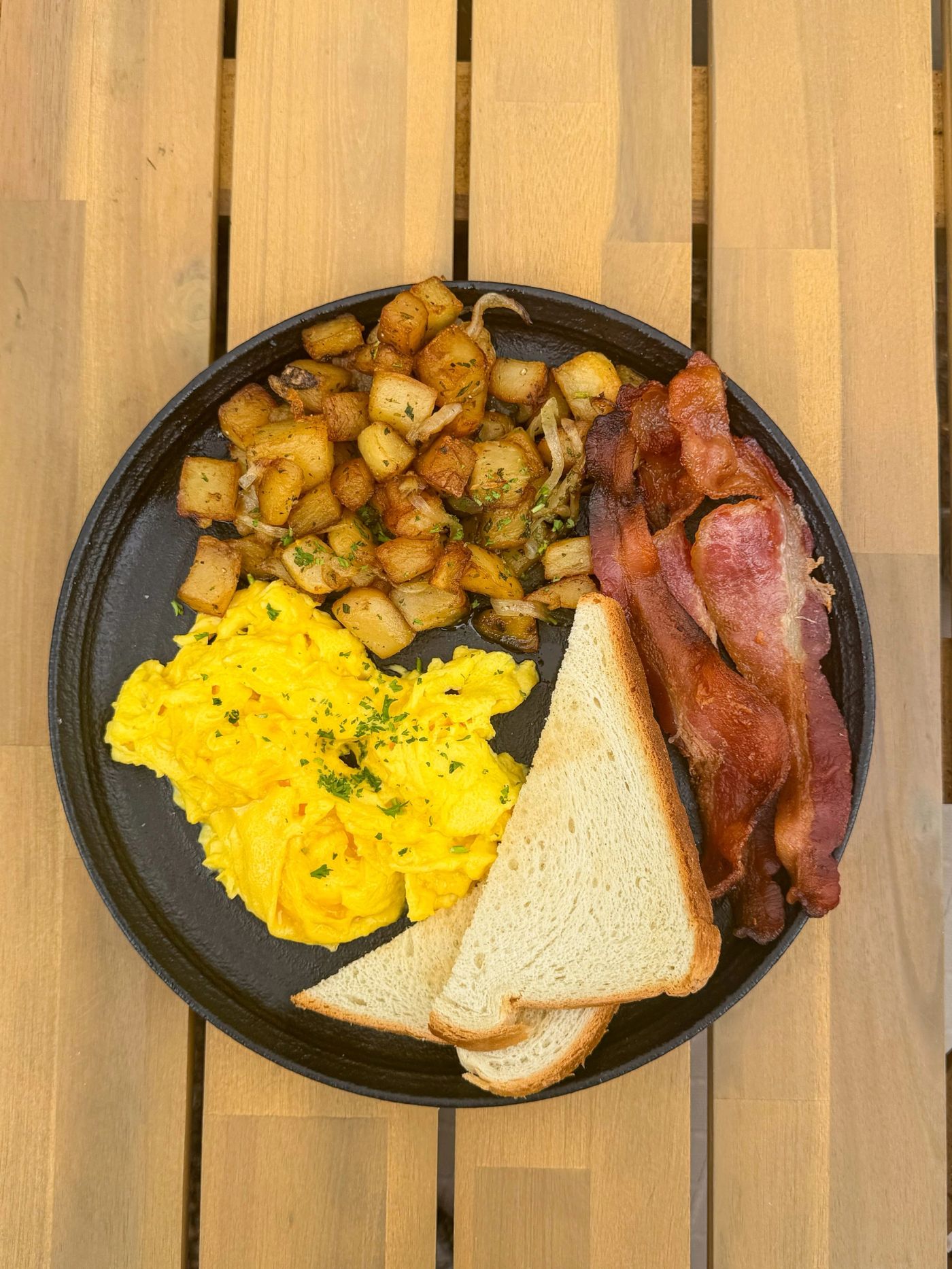 Breakfast plate with eggs, bacon and potatoes