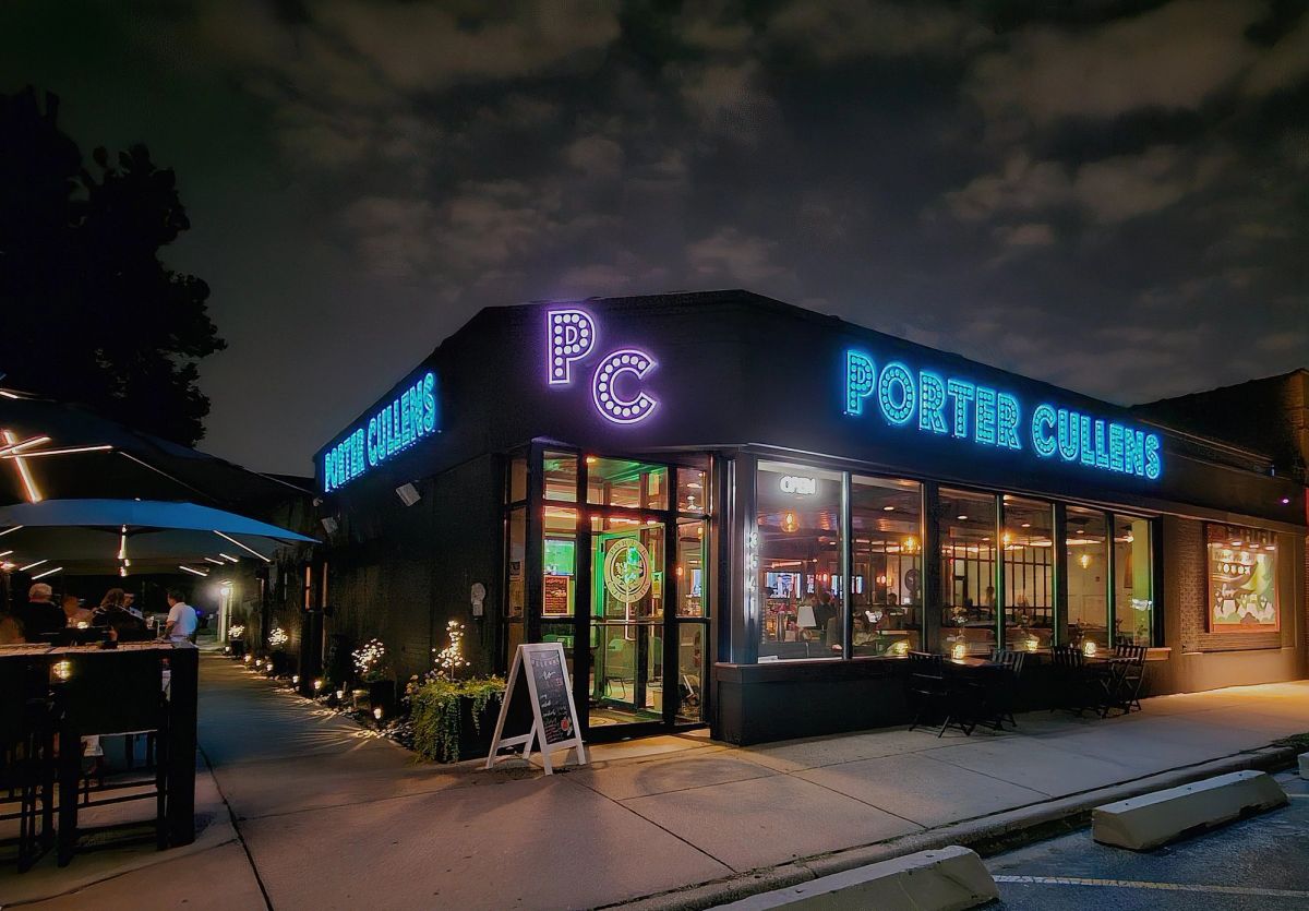 Porter Cullens exterior at night with glowing neon signage and patio seating