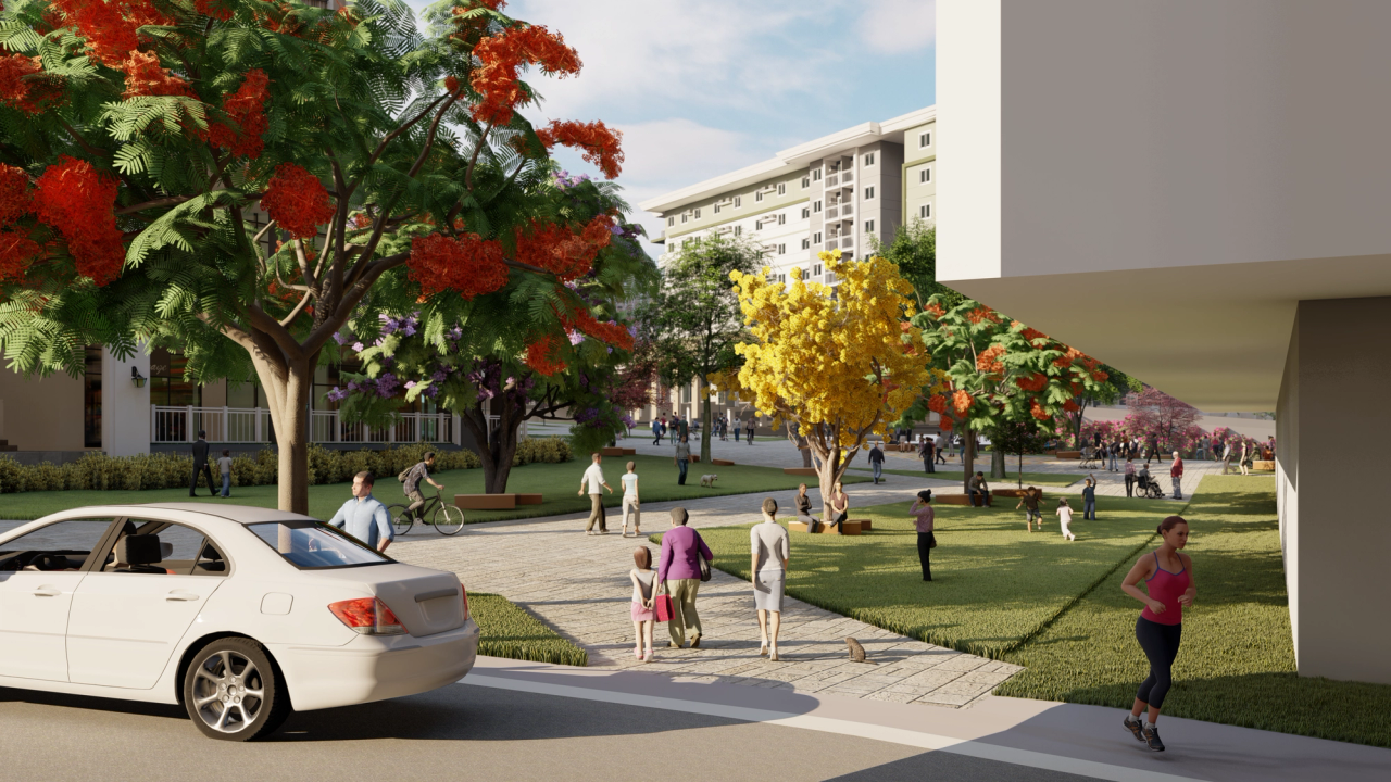 Rendered street-level view of a lively urban park area with people walking, jogging, cycling, and socializing. A white car is parked in the foreground, while colorful trees with red, yellow, and purple blossoms line the walkways. Mid-rise residential buildings are visible in the background, creating a vibrant and welcoming neighborhood atmosphere.