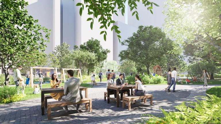 People enjoy a vibrant urban park with lush greenery. Some are sitting at picnic tables talking, while others walk or play in the background. The park features mature trees, landscaped paths, and children playing on swings, all set against a backdrop of tall modern buildings. Sunlight filters through the leaves, creating a bright and inviting atmosphere.