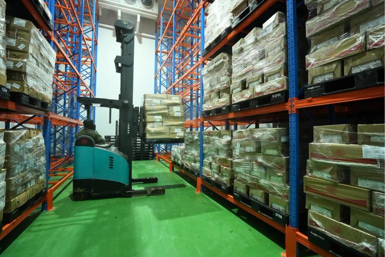 Inside the Artico Cold Chain facility. A forklift operator efficiently storing products on racks in the cold room.  