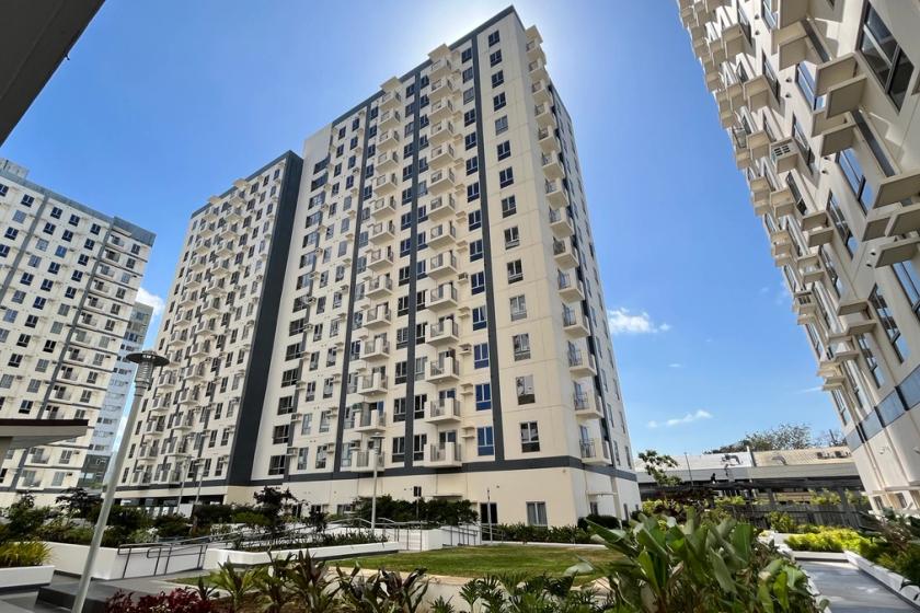 A prominent apartment complex featuring a well-maintained garden in front, enhancing the residential environment.