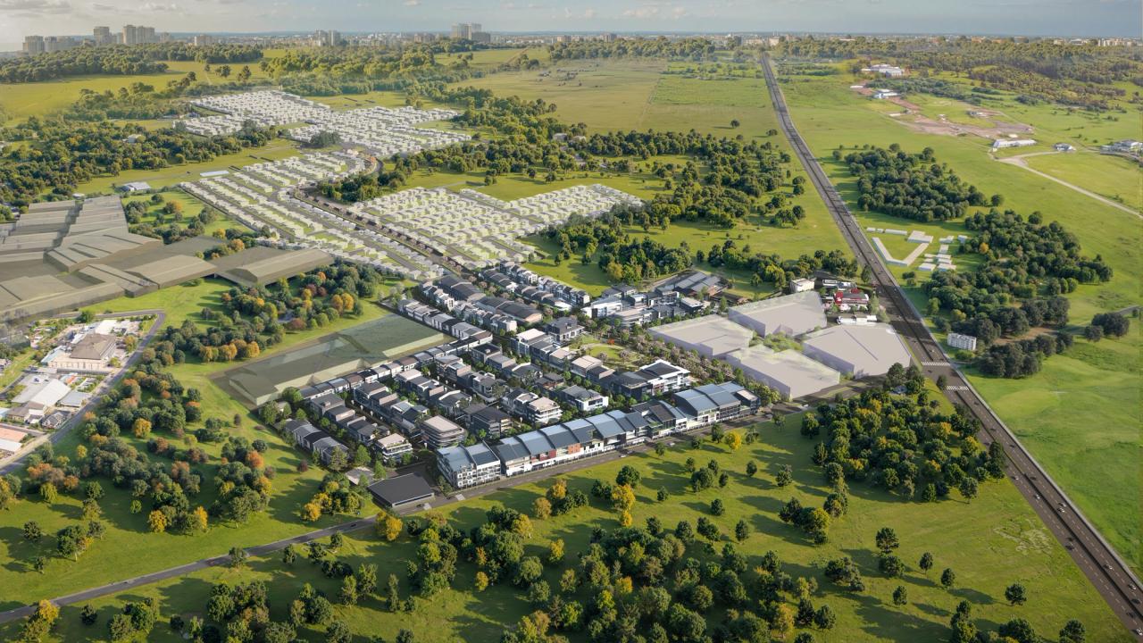 Expansive aerial view of a master-planned suburban community, featuring residential enclaves, commercial areas, tree-lined streets, and open green spaces—set against a backdrop of wide landscapes and accessible road networks.