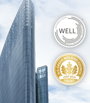 A modern glass skyscraper with the U.S. Green Building Council LEED Gold certification logo prominently displayed in the foreground.
