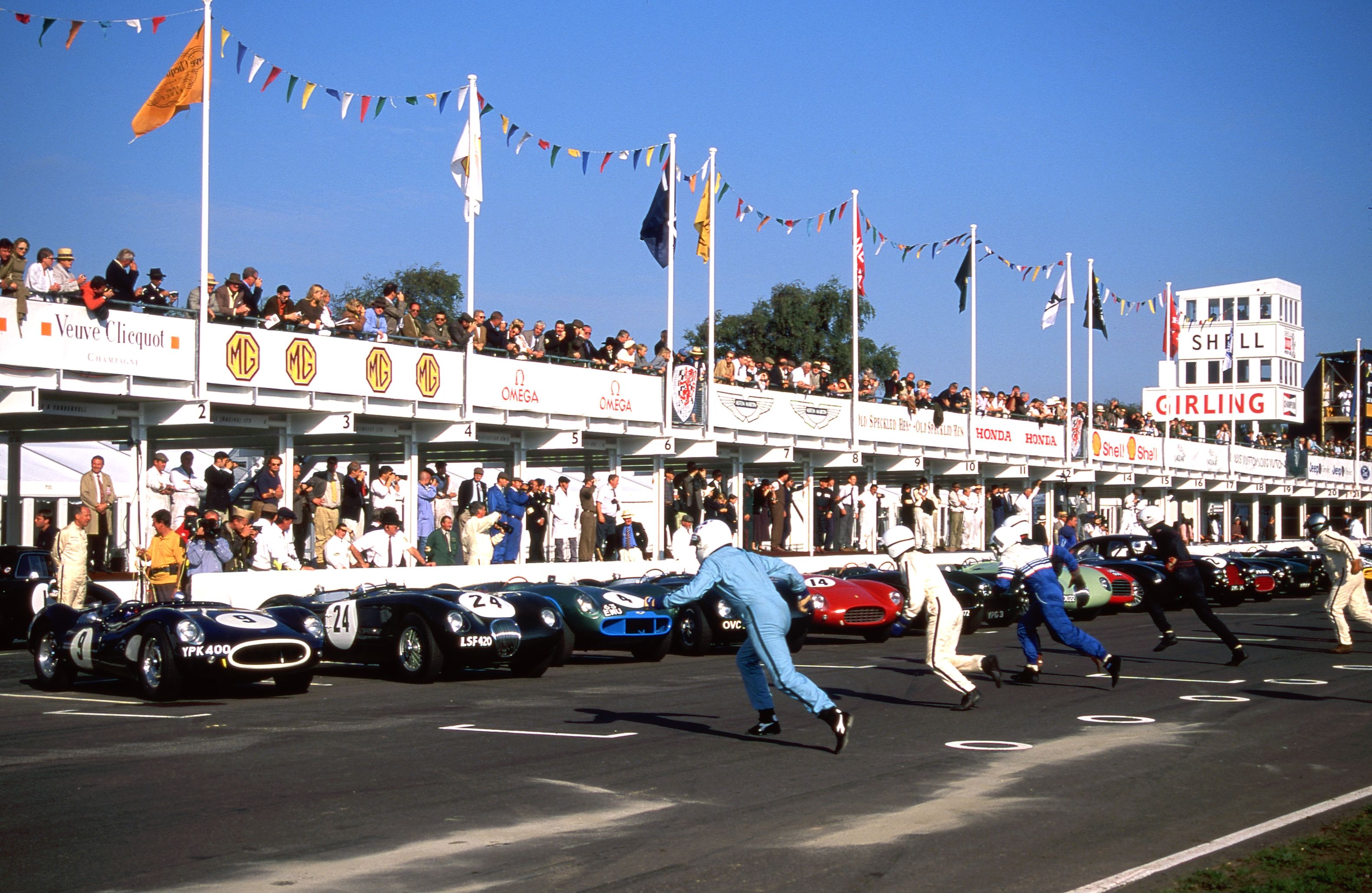 Crowd of attendees at the Goodwood Festival of Speed taking photos of the large white car sculpture.