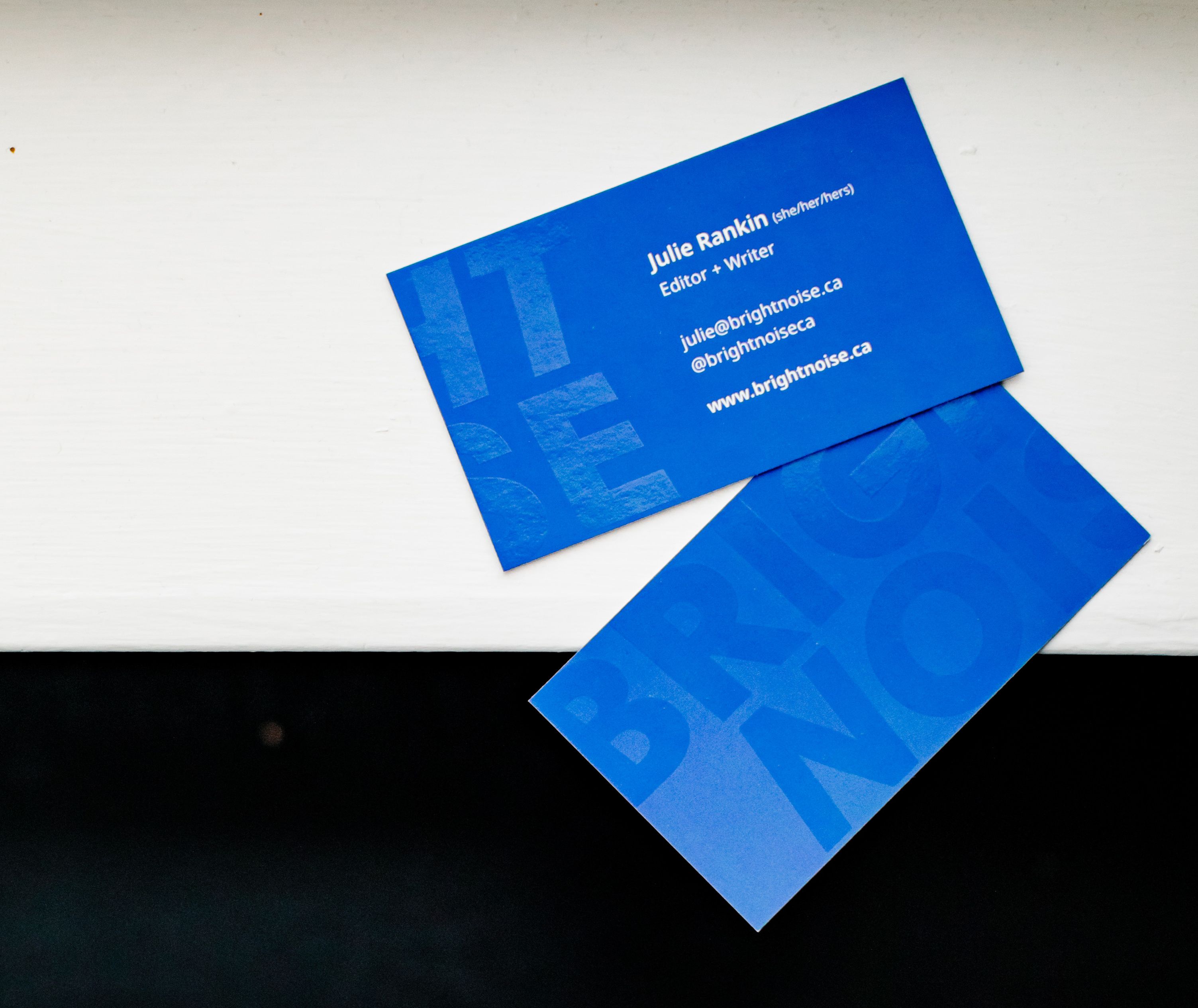 Bold, purple business cards display the logo Bright Noise on the front and back in a spot gloss finish.