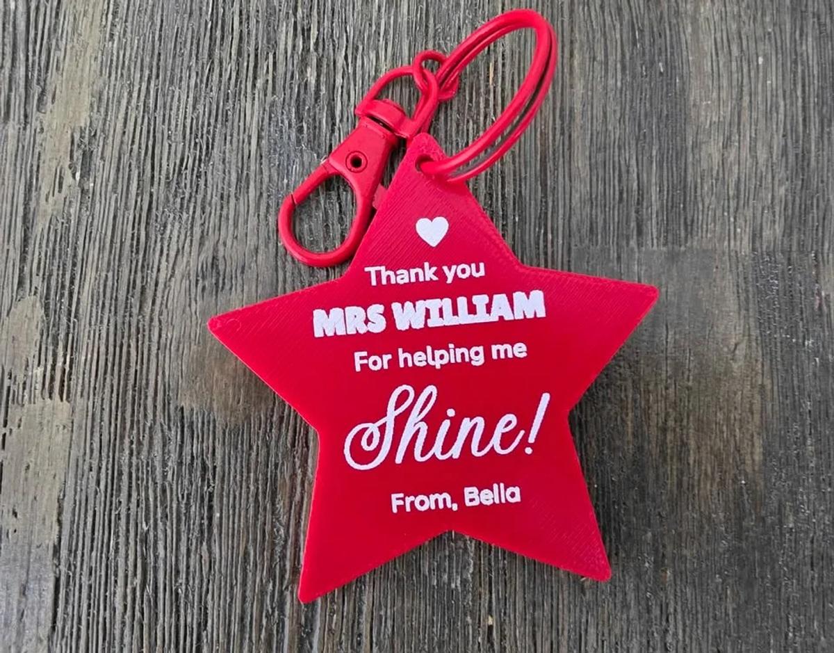 A star keychain printed in full colour with a teacher's name and a student's name.