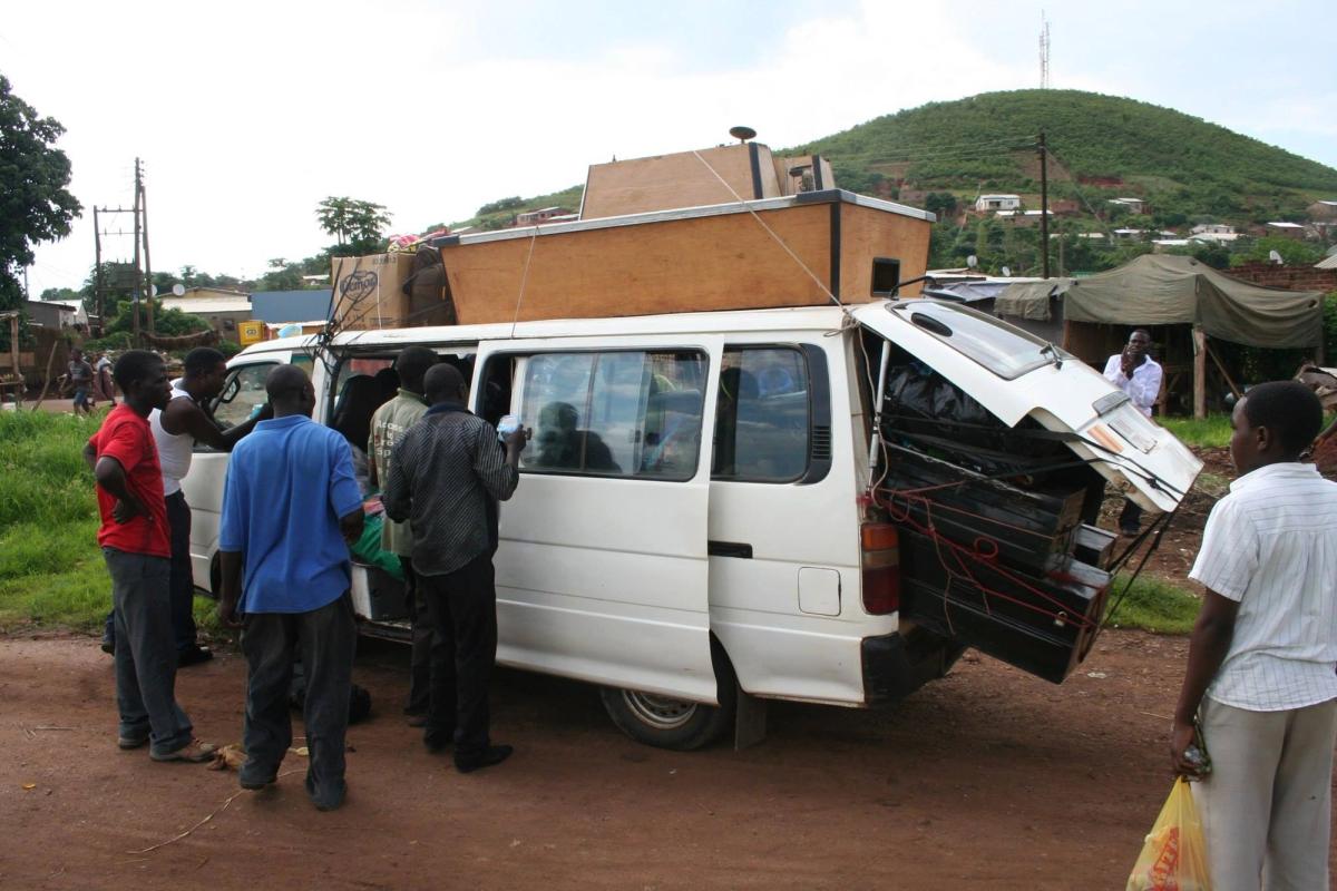 Crowded bus in Zambia with billiards table on roof