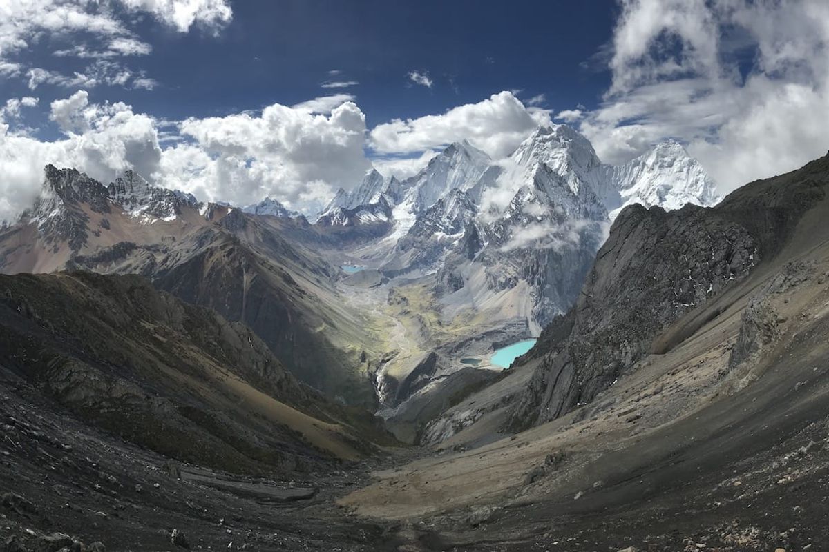 Glacial valley with a turquoise lake beneath snowy Andean peaks