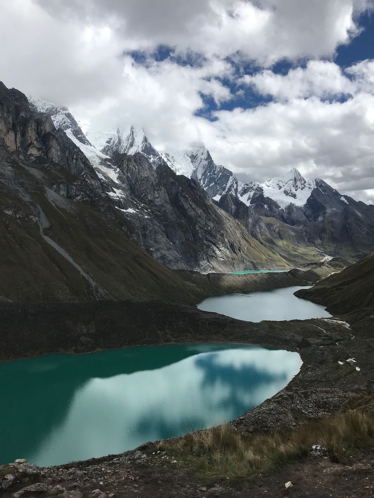 2 green lakes in a valley of snow capped mountains