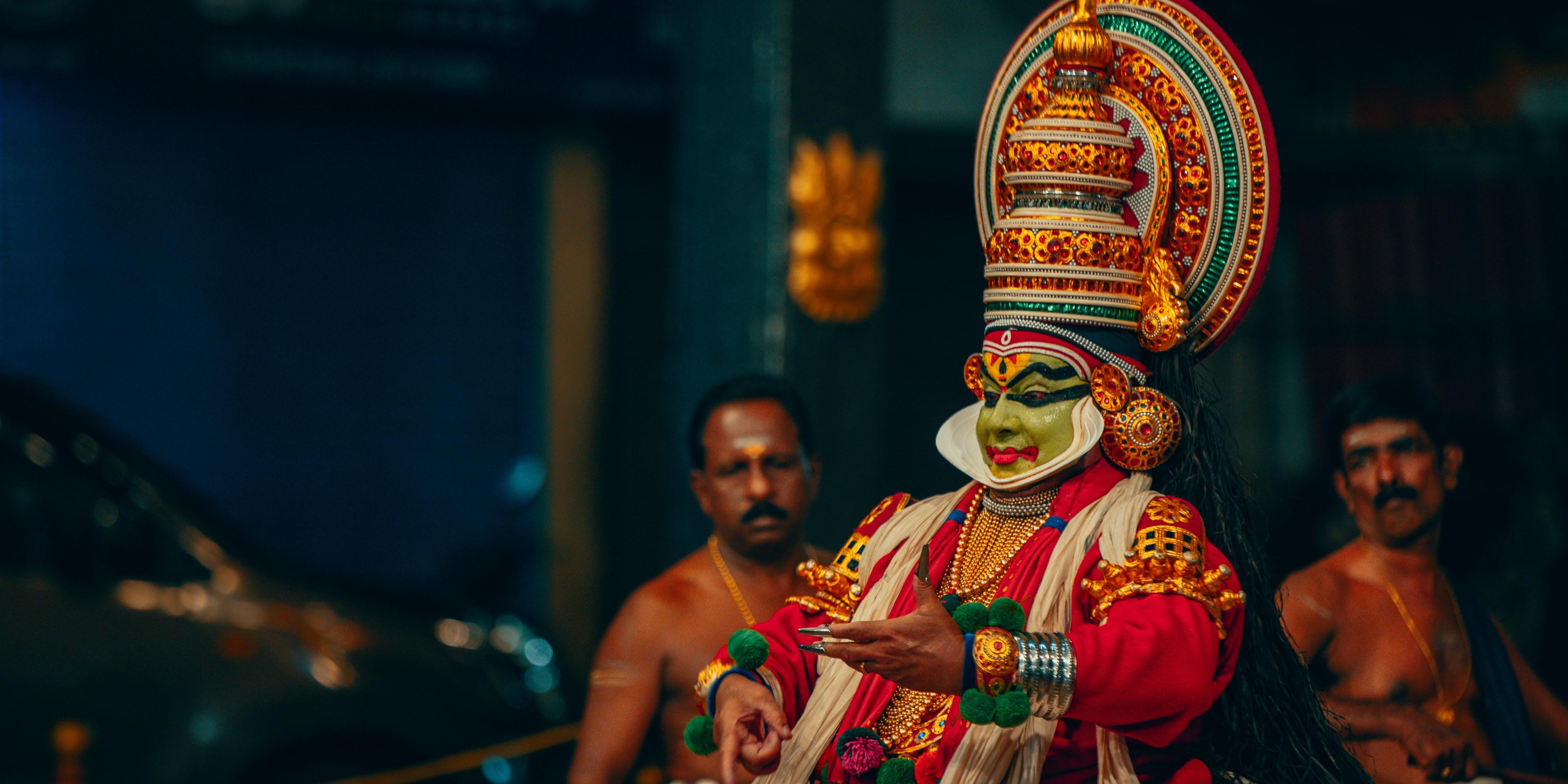 a man in a colorful costume is dancing in front of a crowd .
