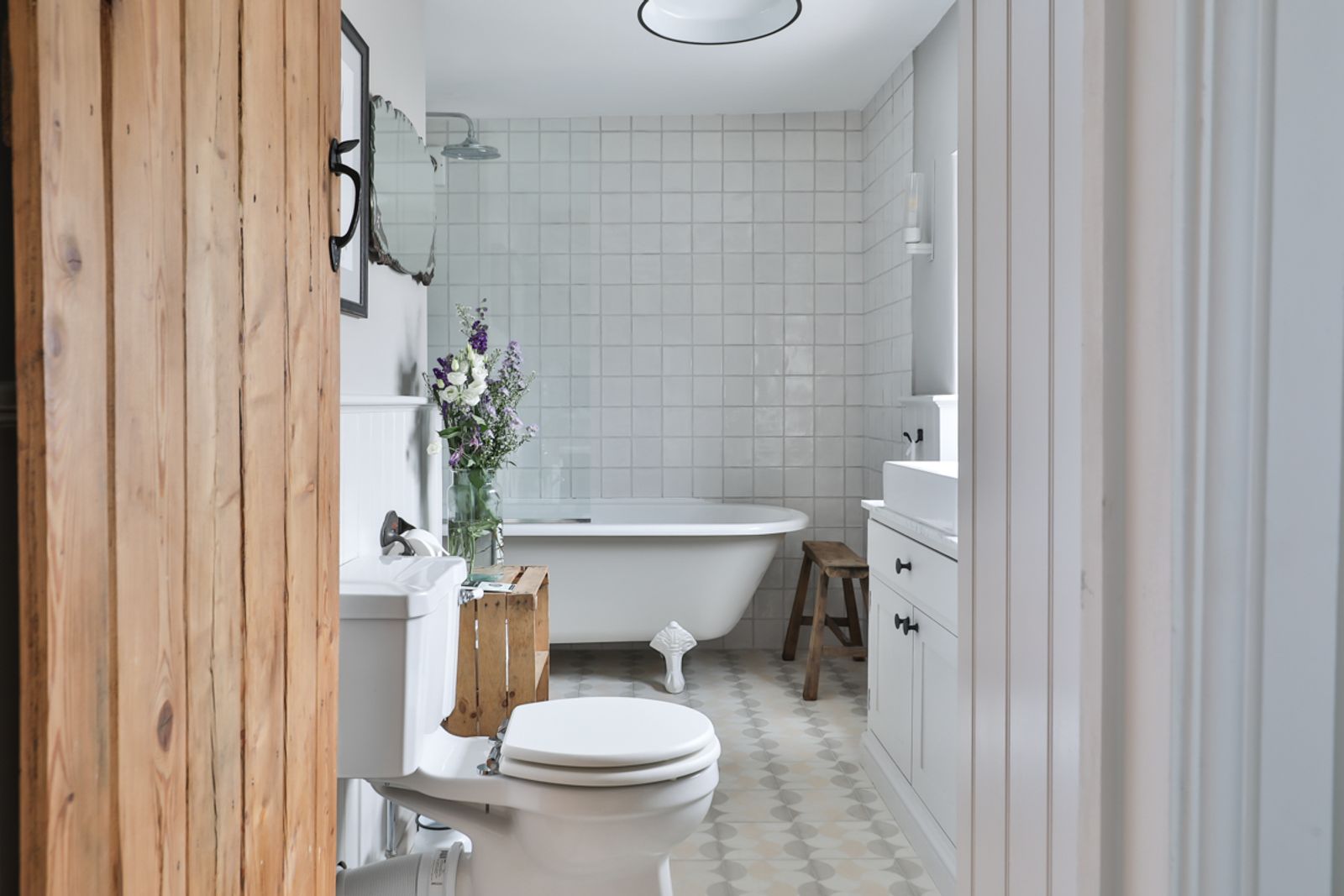 Bathroom with toilet, sink and light wood paneling