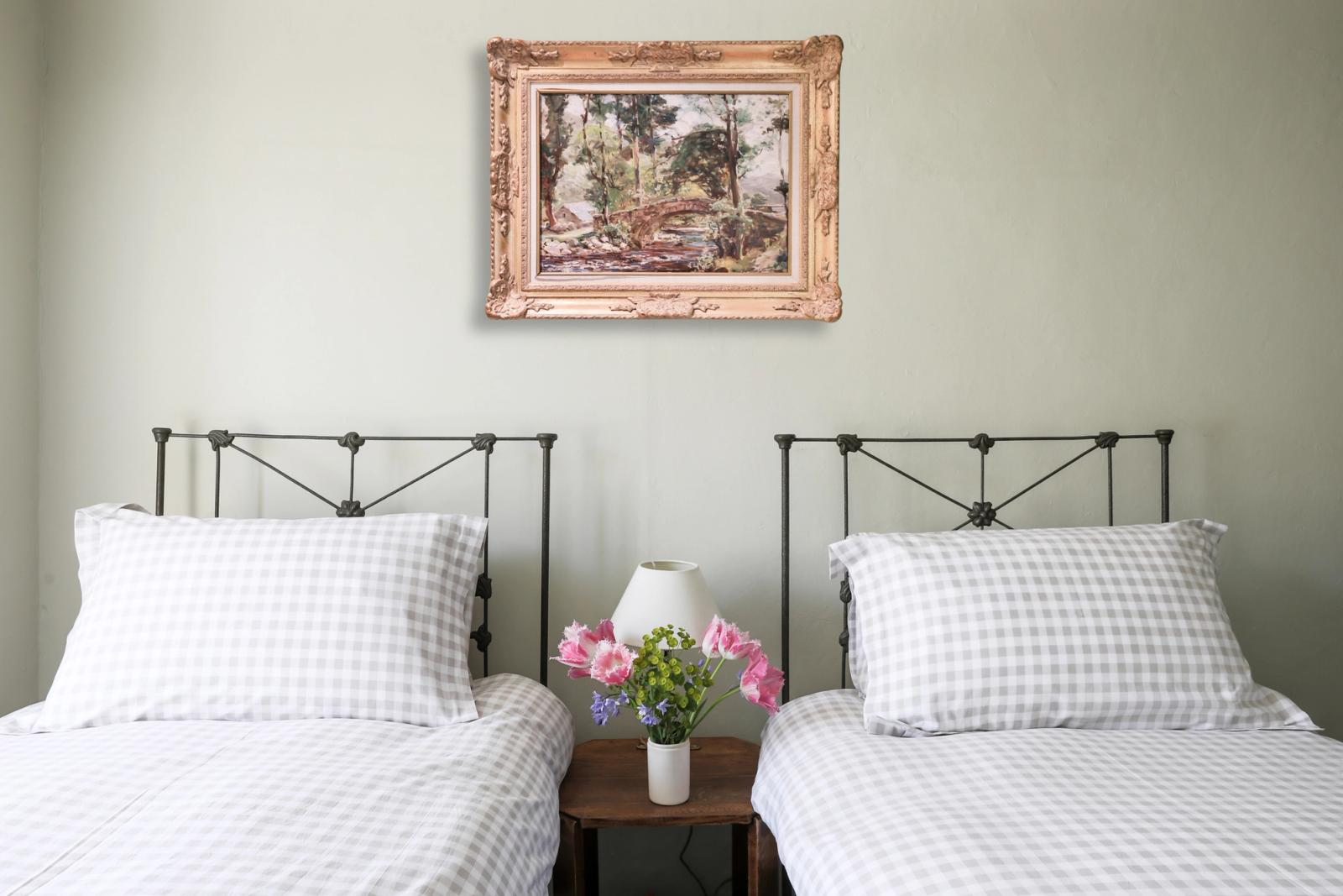 Twin bedroom with two beds, white bedding, iron headboards, and cream walls