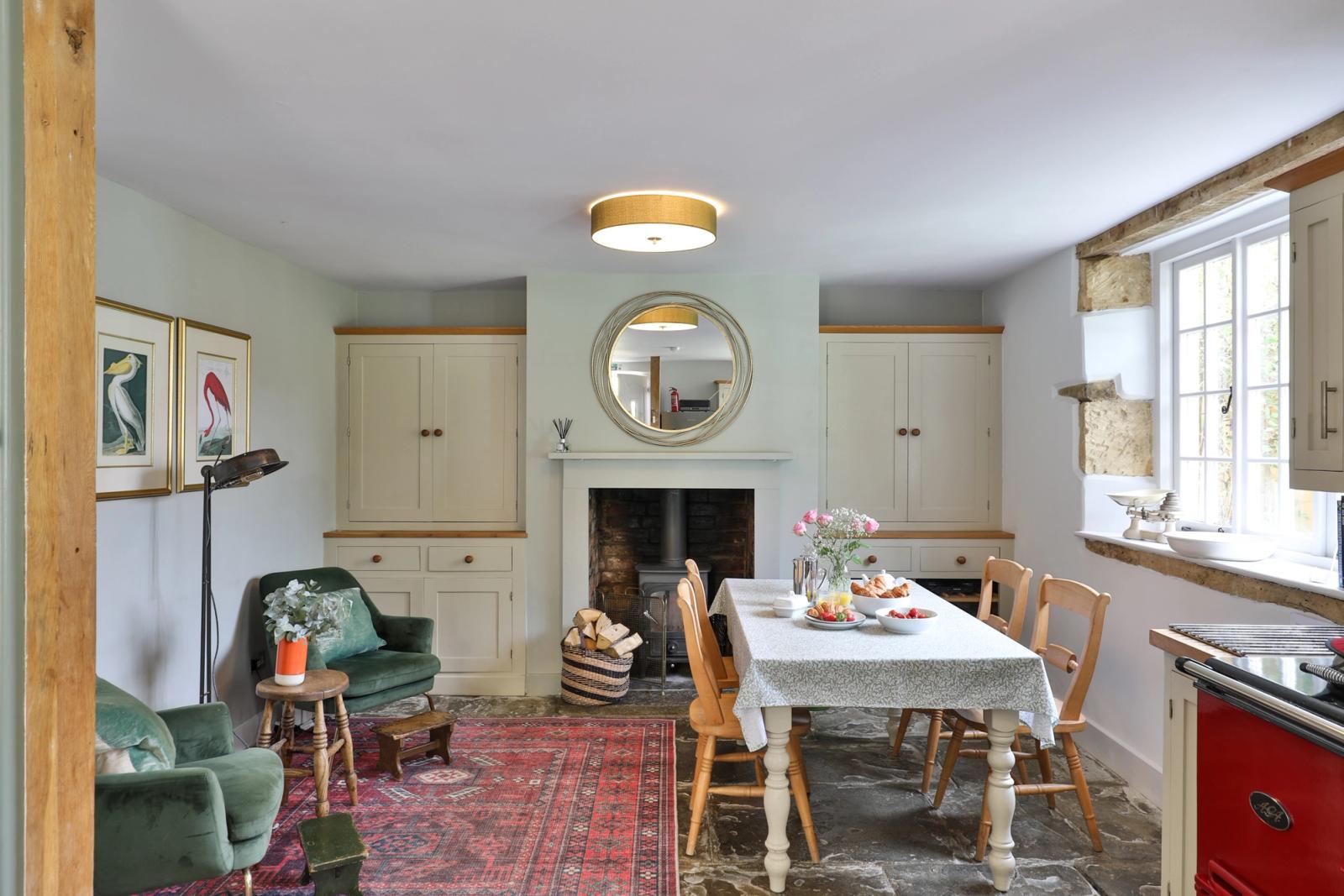 Dining room with wooden table, chairs, cream walls, and fireplace