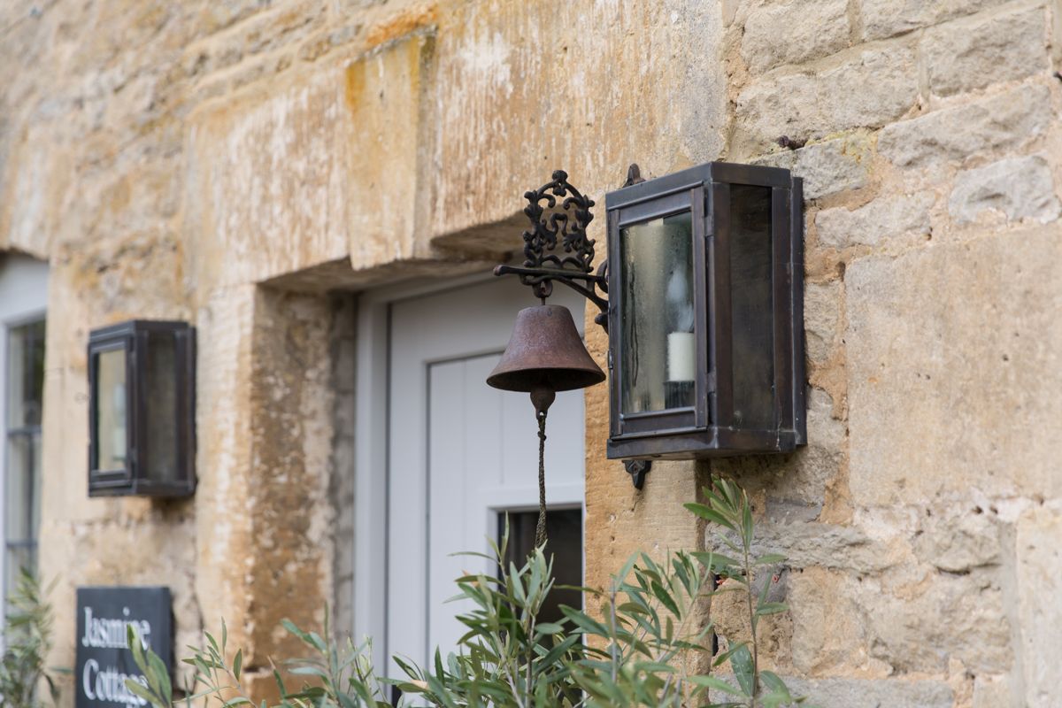 Honey-stone cottage exterior with front door and lantern