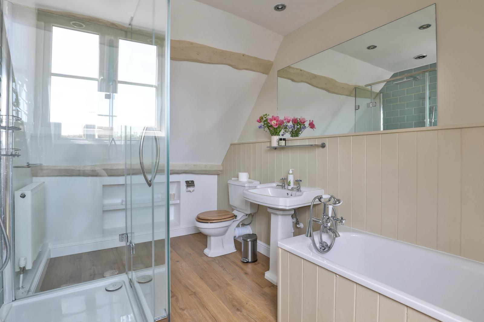 Bathroom with glass shower enclosure, vanity sink, and natural lighting