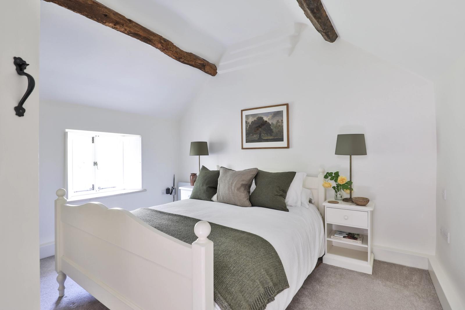 Spacious master bedroom with exposed wooden beams