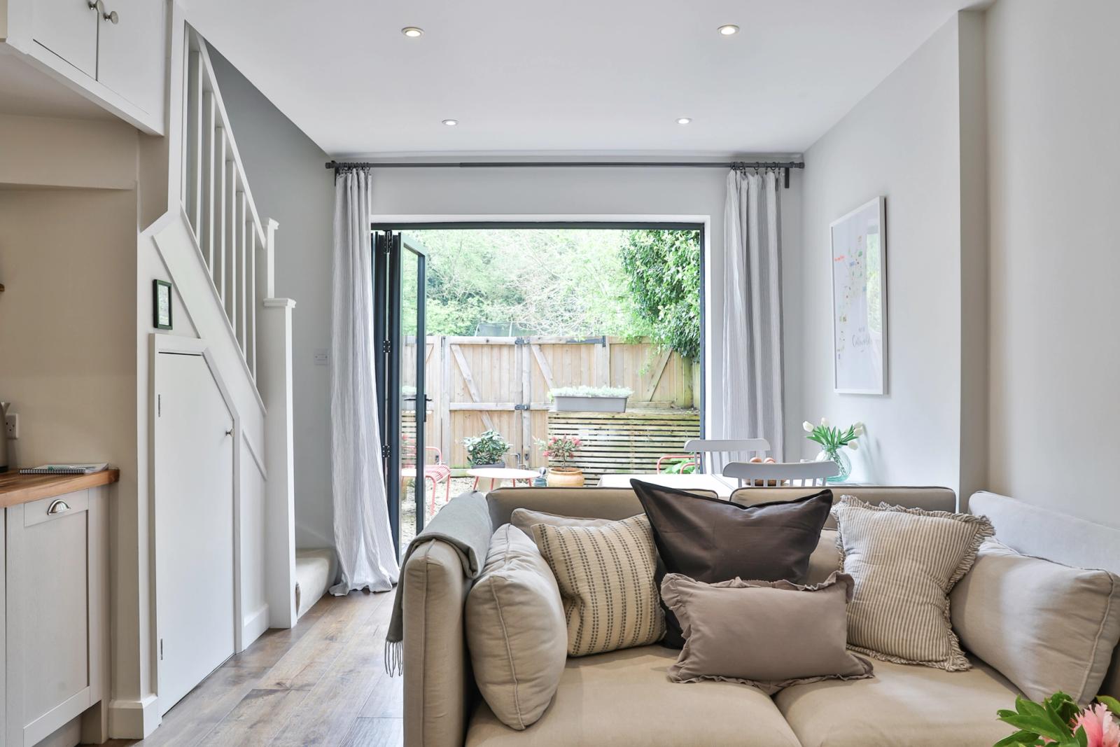 Bright lounge with cushioned seating, large windows, garden views, natural light, comfortable furnishings