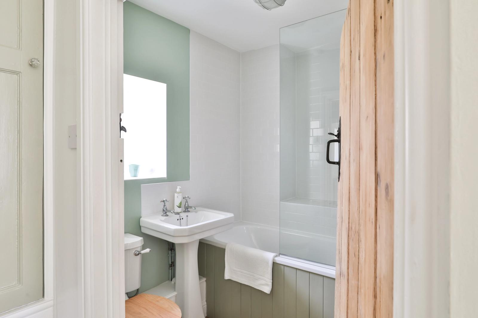Bathroom with white walls, sink vanity, and shower enclosure