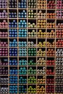 a shelf filled with lots of different colored spray paint cans .