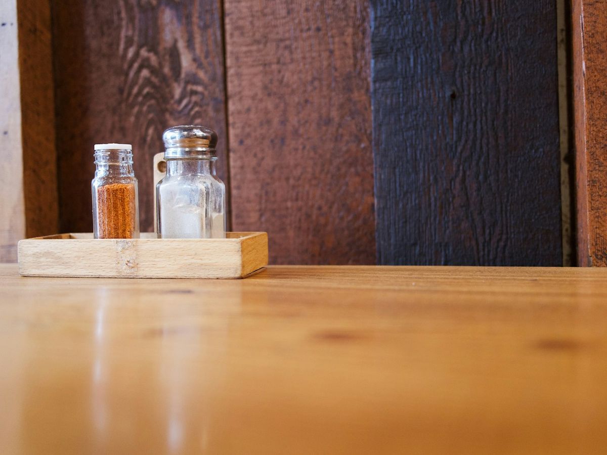 Cedarwood shavings scattered around small amber bottles on a rustic wooden table