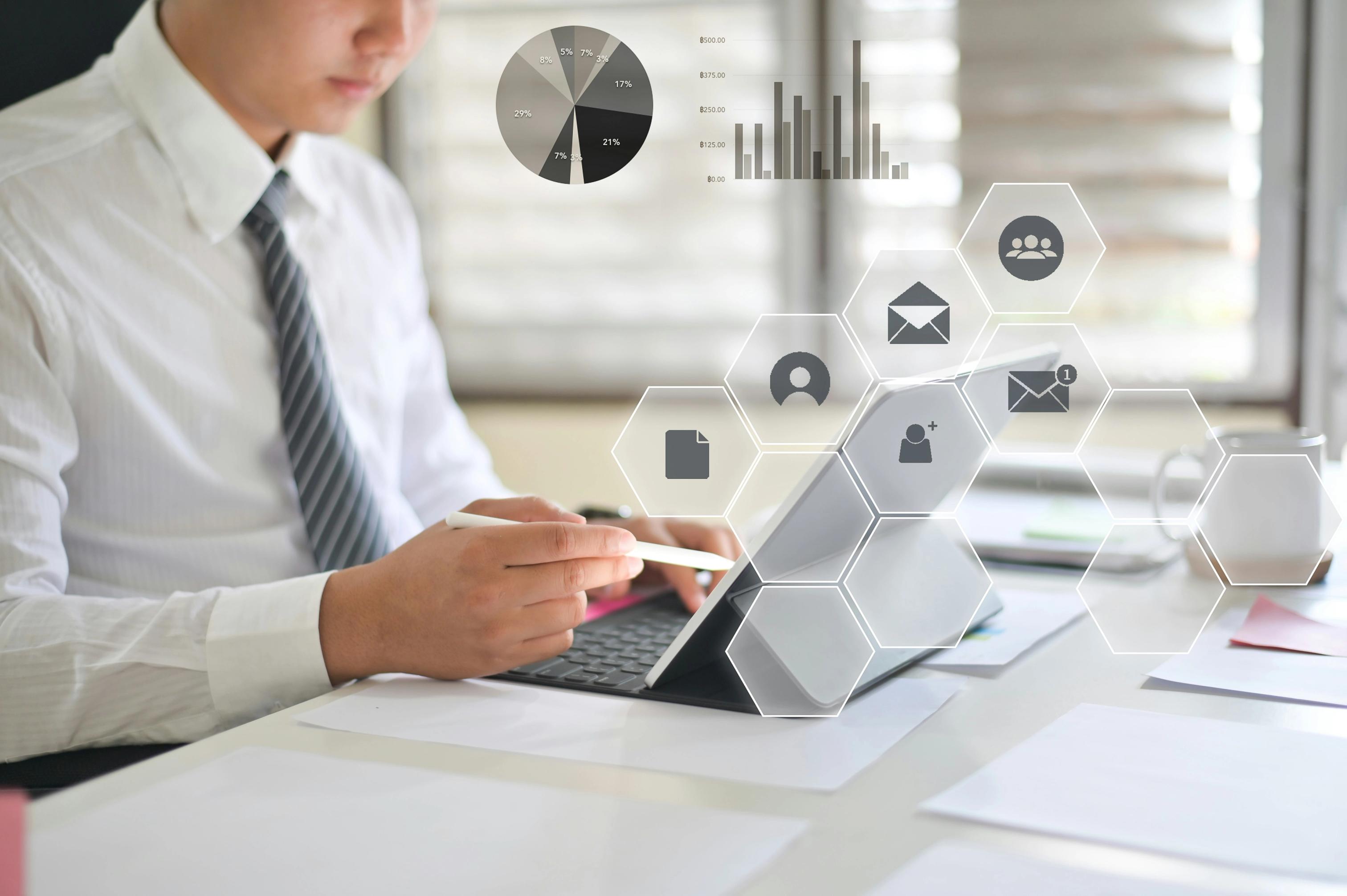 Business professional analyzing data on a tablet with digital analytics and cloud icons overlay.