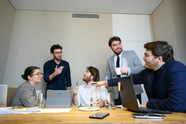 Business team collaborating in a meeting room with laptops and notes, discussing custom web development strategy.