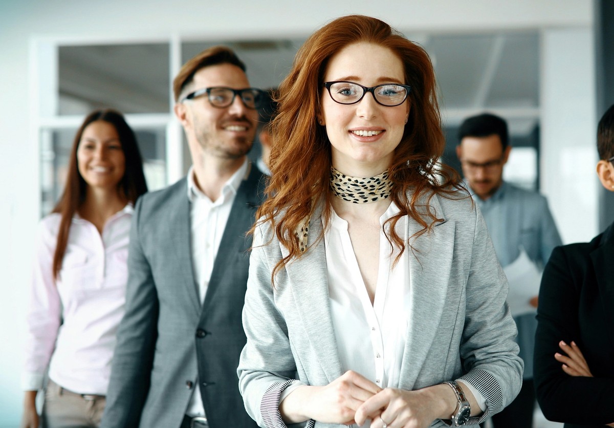 Group of professionals in business attire, confidently standing in an office environment