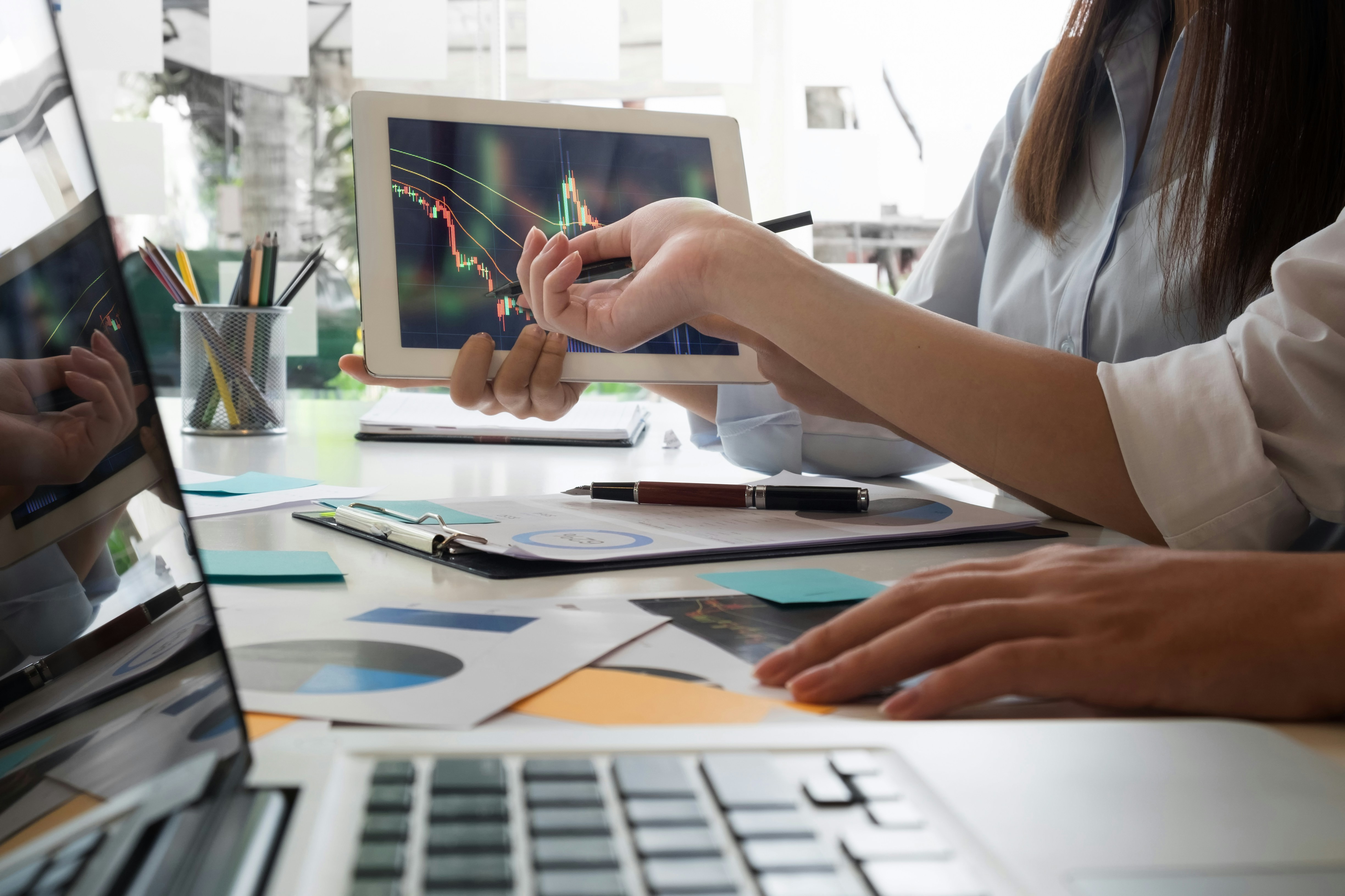 Team reviewing charts and analytics on laptops and tablets during a marketing website strategy session.