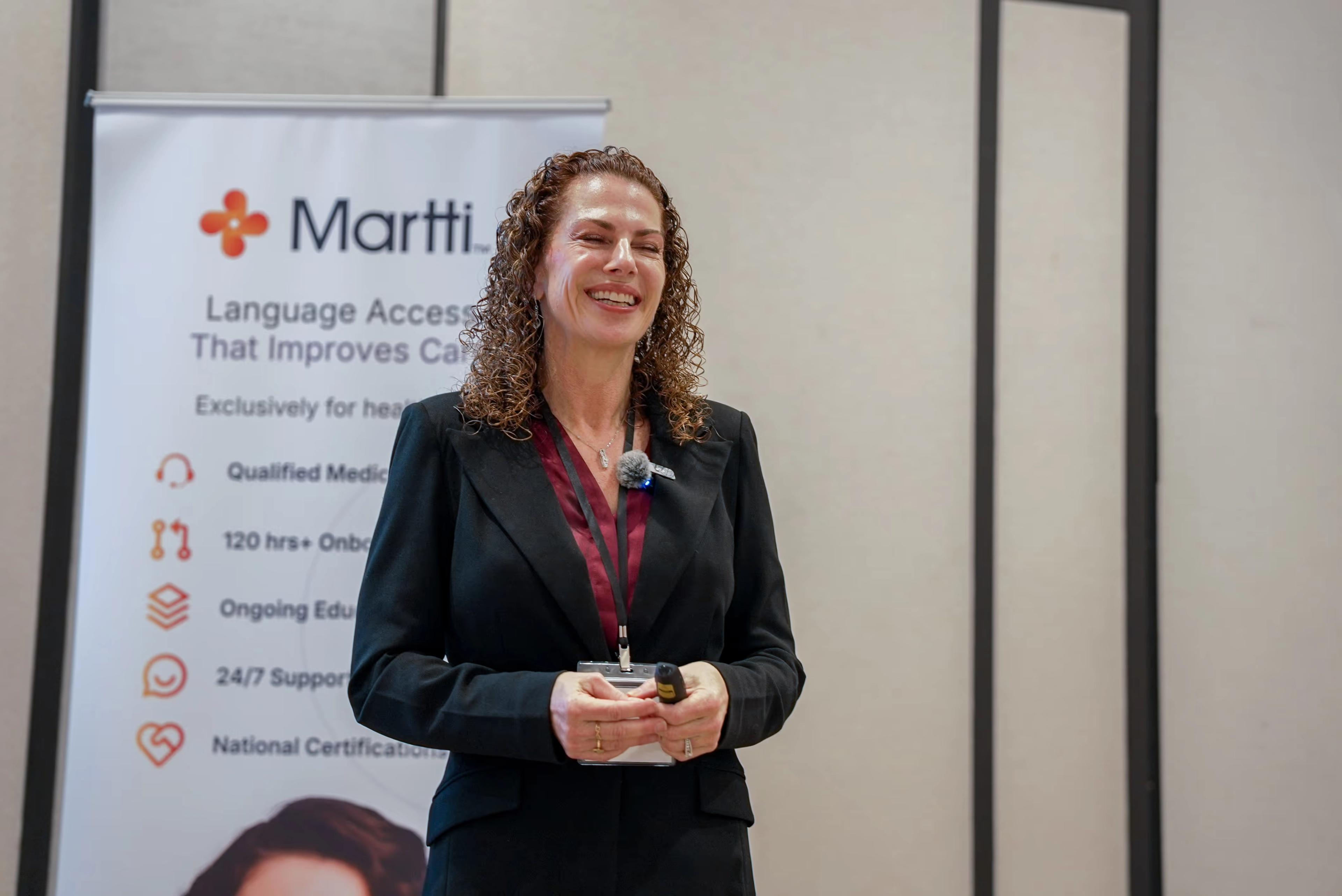 A speaker presents in front of a Martti banner