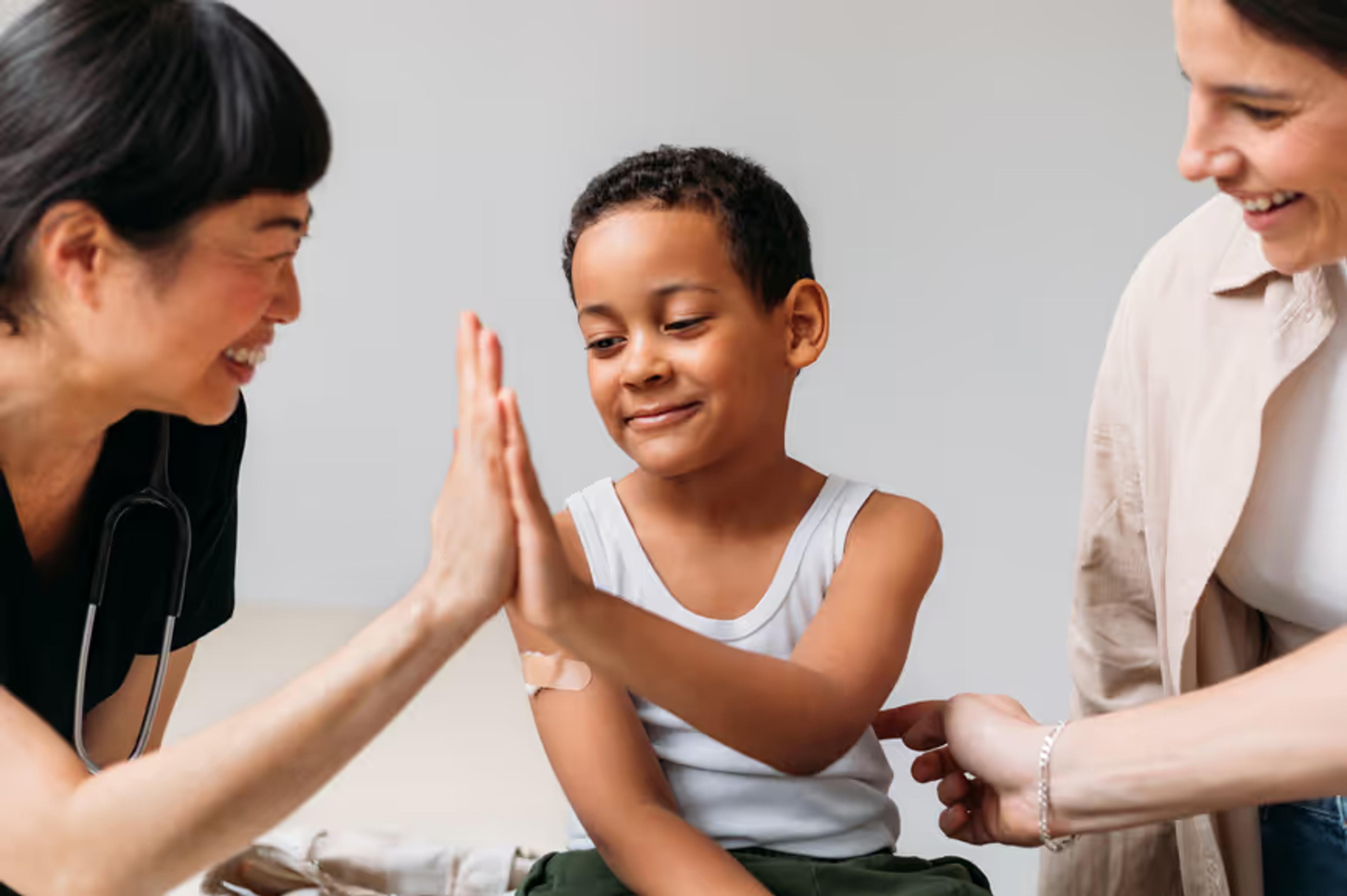 A nurse high-fives a young patient