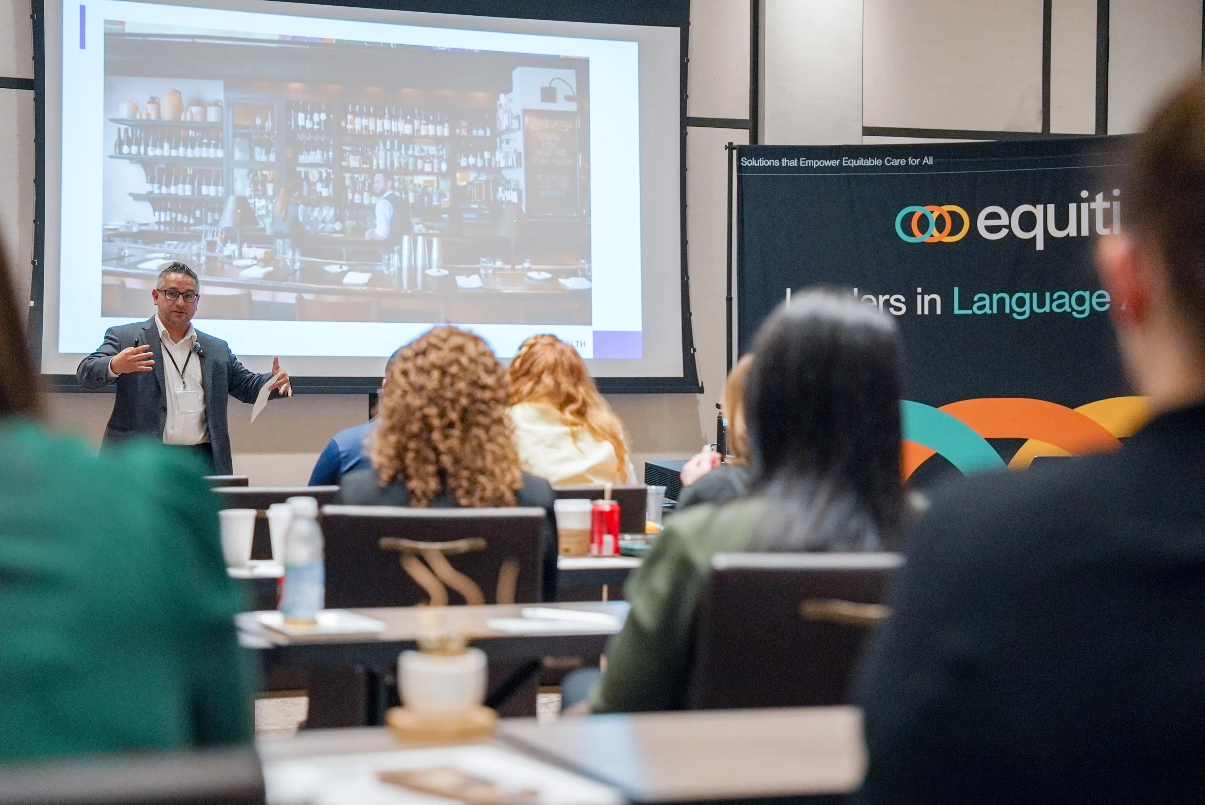 An audience listens to a presentation at an Equiti event