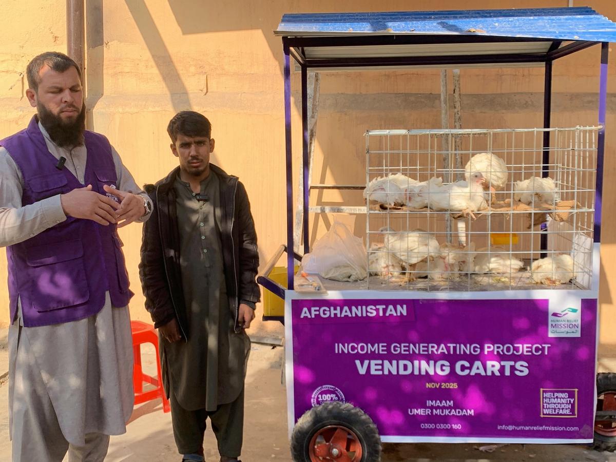 Afghan man with his chicken cart (IGP) with Human Relief Mission aid worker