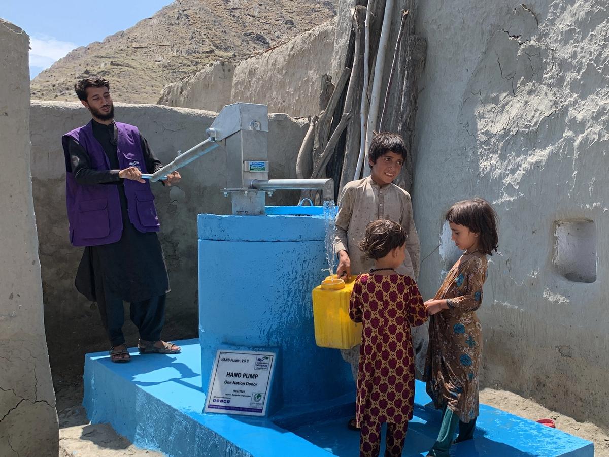Children and HRM Aid worker with a handpump in Afghanistan | Human Relief Mission