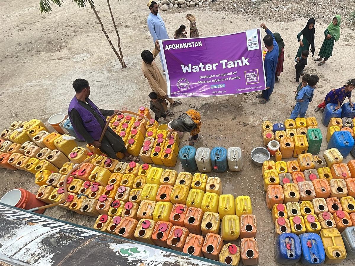 Birds eye view of man in Afghanistan pouring water into buckets with a hose | Human Relief Mission
