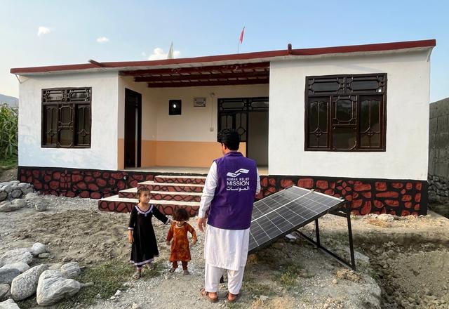 HRM Charity Aid Worker with Children in front of a home in Afghanistan | Human Relief Mission