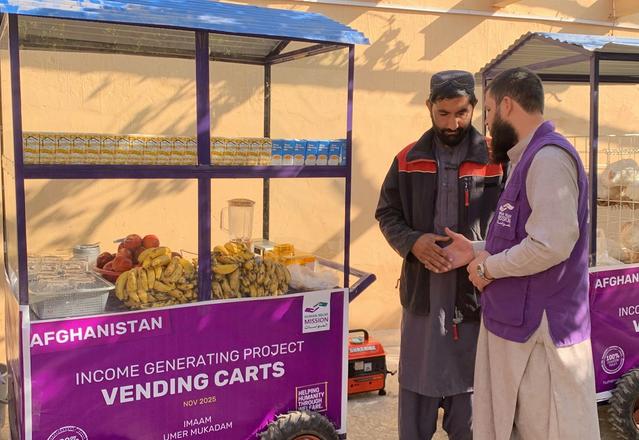 Man with Human Relief Mission aid worker next to his fresh juice cart | Human Relief Mission