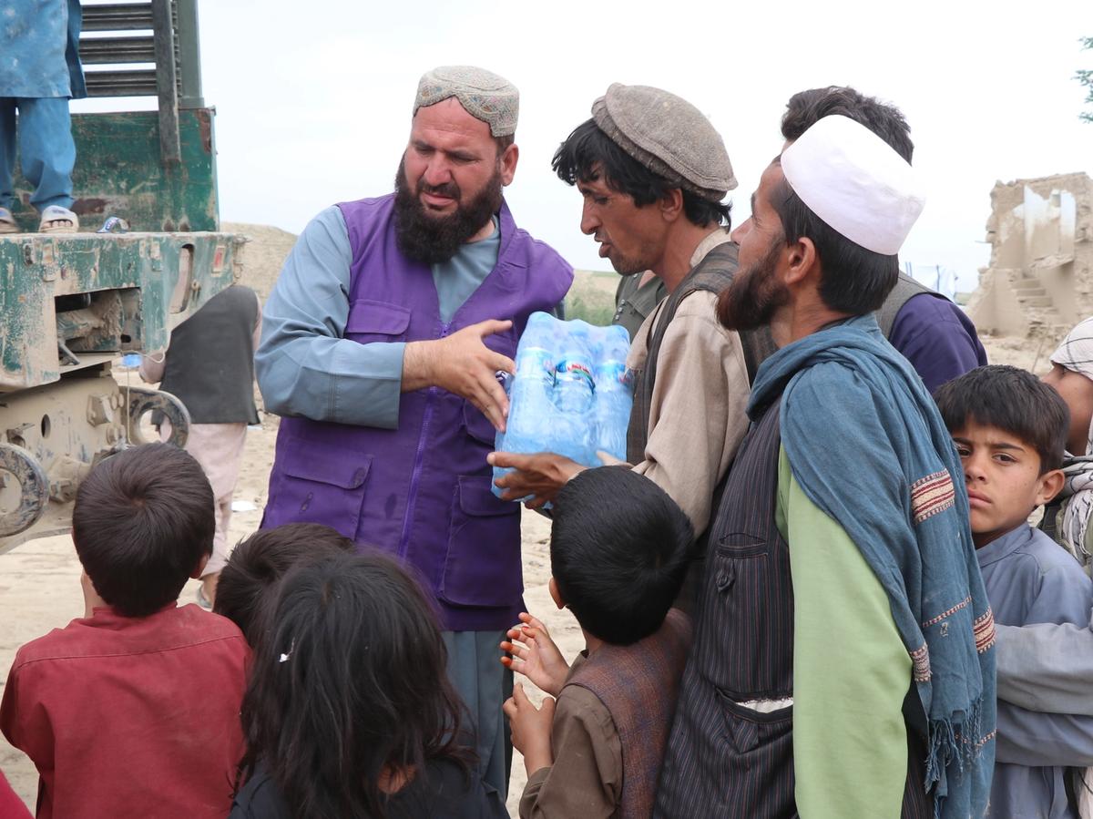 Families in Afghanistan receiving a case of water bottles | Human Relief Mission