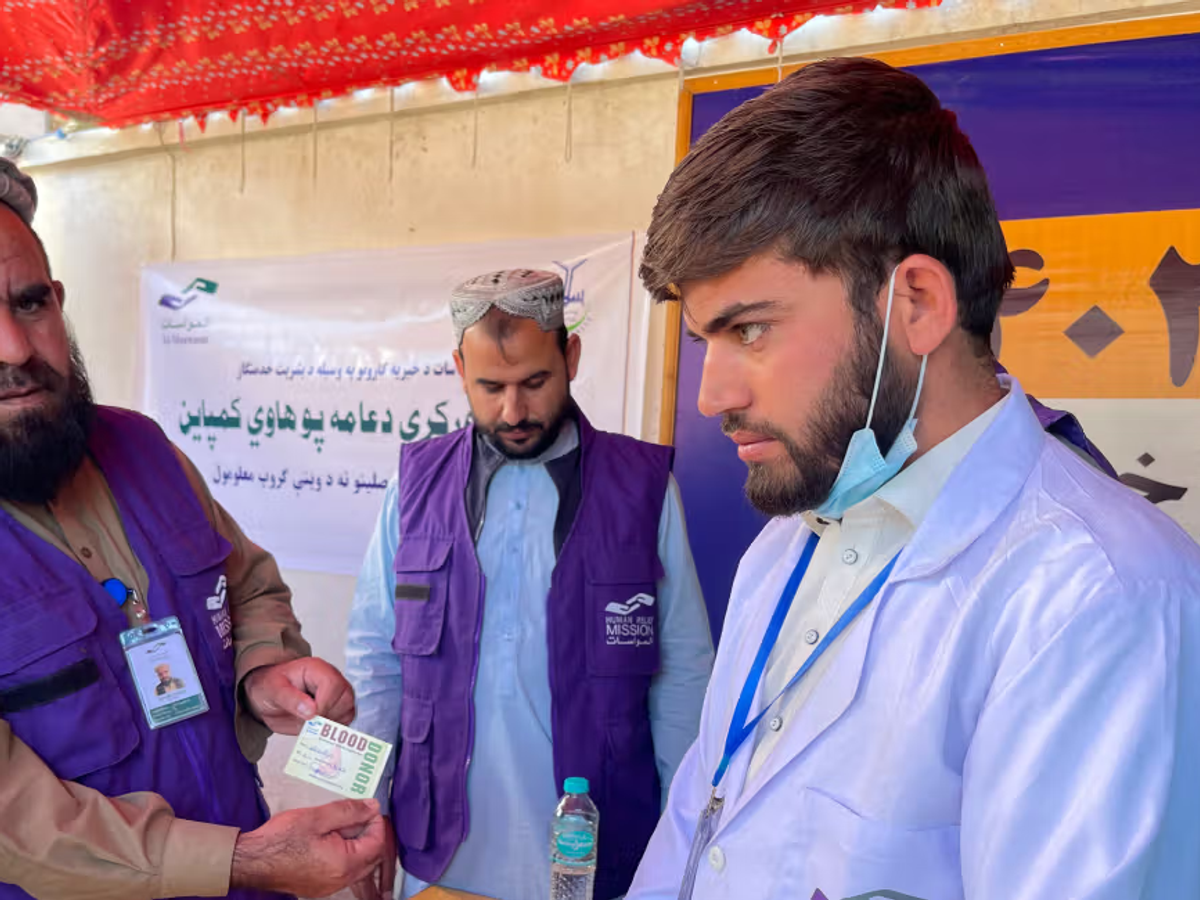 HRM Aid Worker with an ID card next to doctor | Human Relief Mission