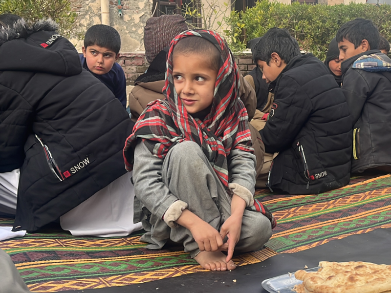 Ahmed eating fresh food while sitting on the floor